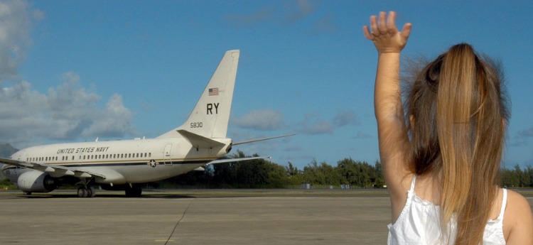 child waving to plane