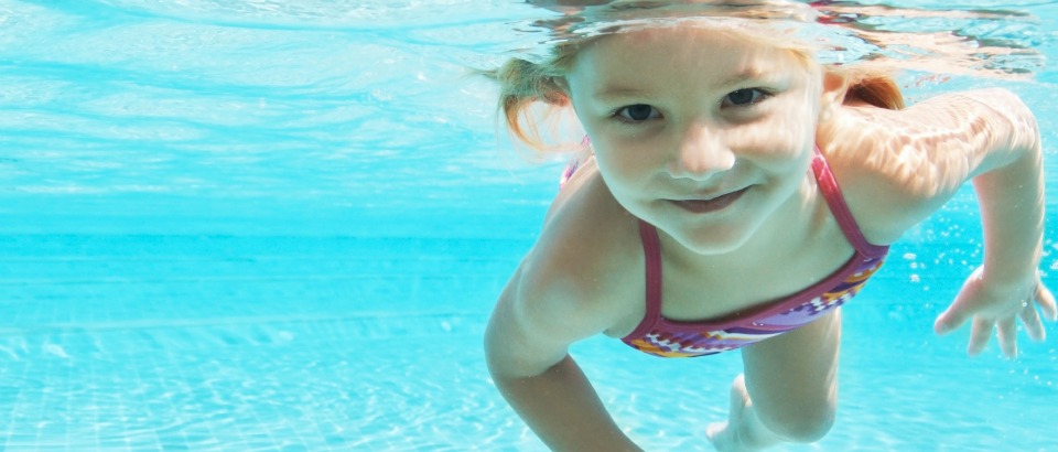 Portrait of a pretty young girl enjoying a swim on a hot day looking at you