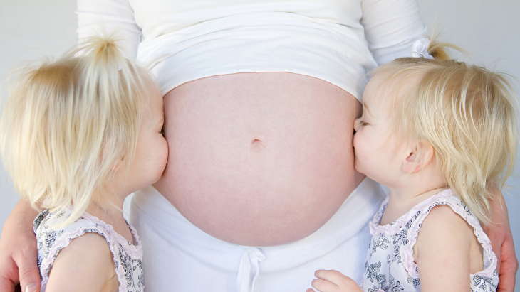 Kids kissing pregnant belly